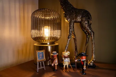 Warm lamp on a shelf with miniature figurines and a bronze giraffe